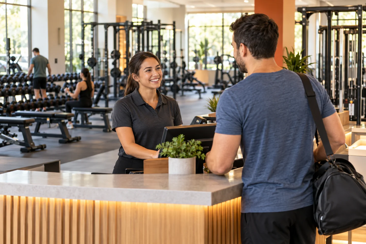 A team member welcoming a guest at gym reception